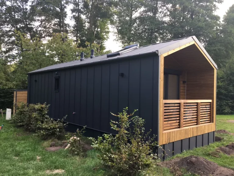 Modernes Mobilheim im Barnhouse-Stil von Compact Haus mit anthrazitfarbener Stehfalzblech-Fassade und integrierter Holzterrasse.