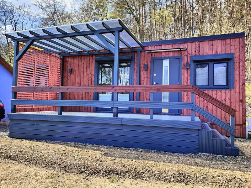 Winterfestes Mobilheim der MONO-Serie von Compact Haus in Holzständerbauweise mit moderner Terrasse und Überdachung.