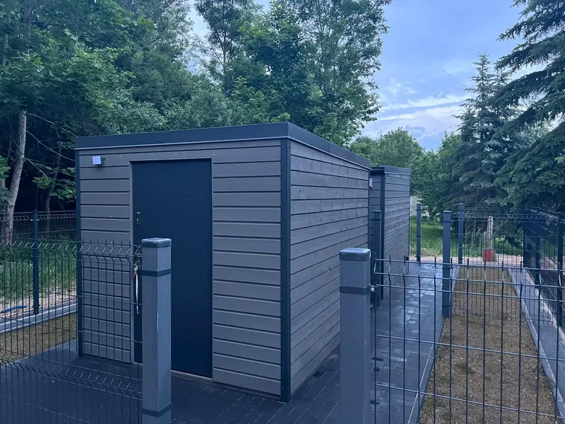 Modernes Gerätehaus aus Holz mit Flachdach im passenden Design zu den Mobilheimen von Compact Haus.