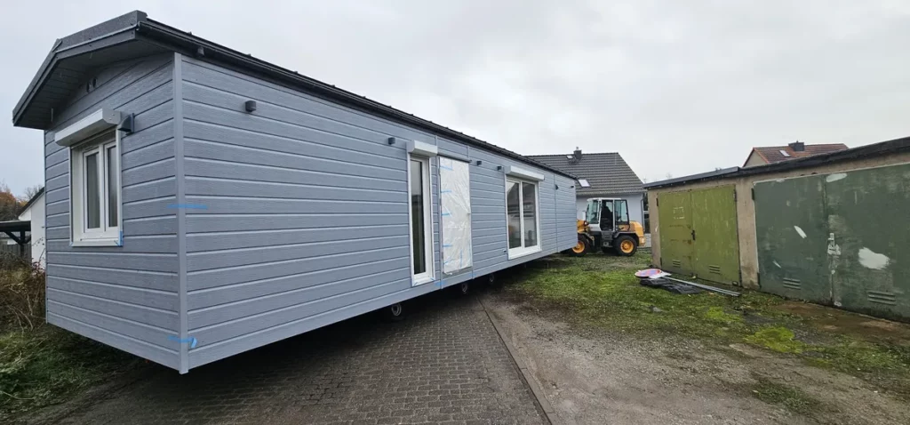 Präziser Transport und bundesweite Anlieferung eines großen Mobilheims von Compact Haus in Hellgrau.