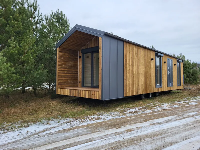 Winterfestes Mobilheim von Compact Haus mit moderner Holzfassade, integrierter Loggia und schneetauglicher Bauweise.