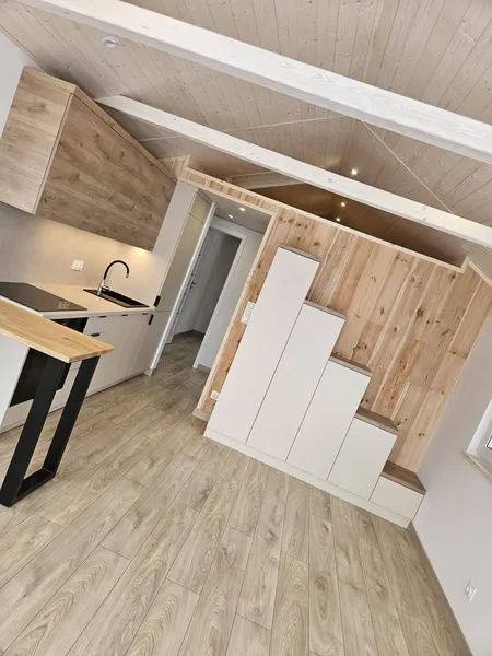 Moderner Innenbereich im Loft-Stil in einem winterfesten Tiny House der MONO-Serie von Compact Haus mit Einbauküche, maßgefertigtem Treppenschrank und Echtholzdecke.
